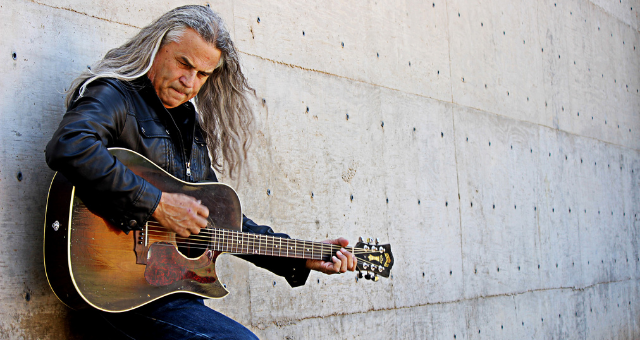 Junior Vasquez posing with guitar